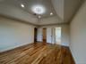 Primary from another house bedroom featuring a walk-in closet, a raised ceiling, light wood-style floors, and recessed lighting