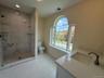 Full bath with vanity, a marble-look shower, light tile patterned floors, and recessed lighting