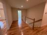 Hallway from another similar home featuring light wood-type flooring, an upstairs landing, and lighting.