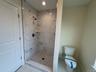 Photos from another house with similar primary bathroom featuring a marble-look shower and tile patterned flooring