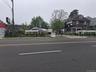 View of asphalt street featuring curbs and sidewalks