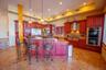 Kitchen with appliances with stainless steel finishes, backsplash, light stone countertops, a center island, and decorative light fixtures