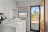 Washroom with washer and clothes dryer and wood walls