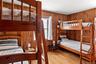 Bedroom featuring light wood-style flooring and wood walls