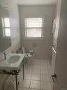 Bathroom with light tile patterned floors, tile walls, and a walk in shower