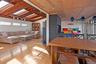 Dining space featuring a skylight, vaulted ceiling, hardwood / wood-style flooring, and wooden walls