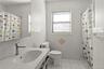 Full bathroom featuring tile walls, curtained shower, light tile patterned flooring, and vanity