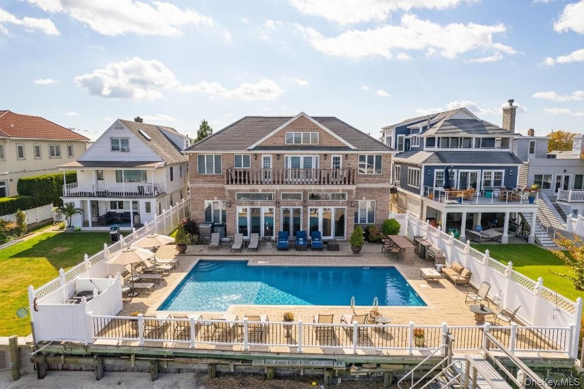 Back of property with a patio, a balcony, and a fenced backyard