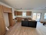 Kitchen featuring brown cabinets, a center island, light wood-style flooring, and dark cabinets
