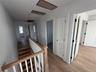 Corridor with attic access, light wood finished floors, and an upstairs landing