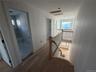 Corridor featuring an upstairs landing and wood finished floors