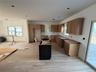 Kitchen with a center island, brown cabinets, light wood-type flooring, recessed lighting, and dark cabinets