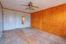 Unfurnished bedroom featuring ceiling fan, light hardwood / wood-style floors, ornamental molding, and two closets