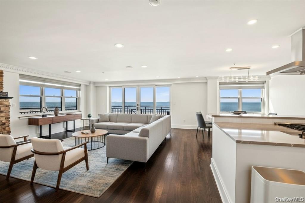 Living room featuring dark wood-style flooring, recessed lighting, and a water view