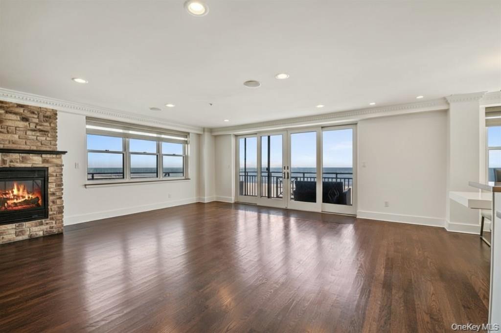 Unfurnished living room with a fireplace, dark wood-style floors, and recessed lighting