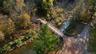 Drone / aerial view of a nearby body of water and a tree filled landscape