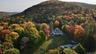 Aerial view of property and surrounding area with a mountainous background and a heavily wooded area