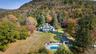 View from above of property with a mountainous background and a forest