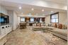 Living area with recessed lighting and light stone finish flooring