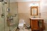 Bathroom featuring tile walls, vanity, a stall shower, and tile patterned floors