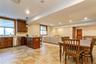 Kitchen with stainless steel dishwasher, a peninsula, light stone counters, recessed lighting, and decorative backsplash