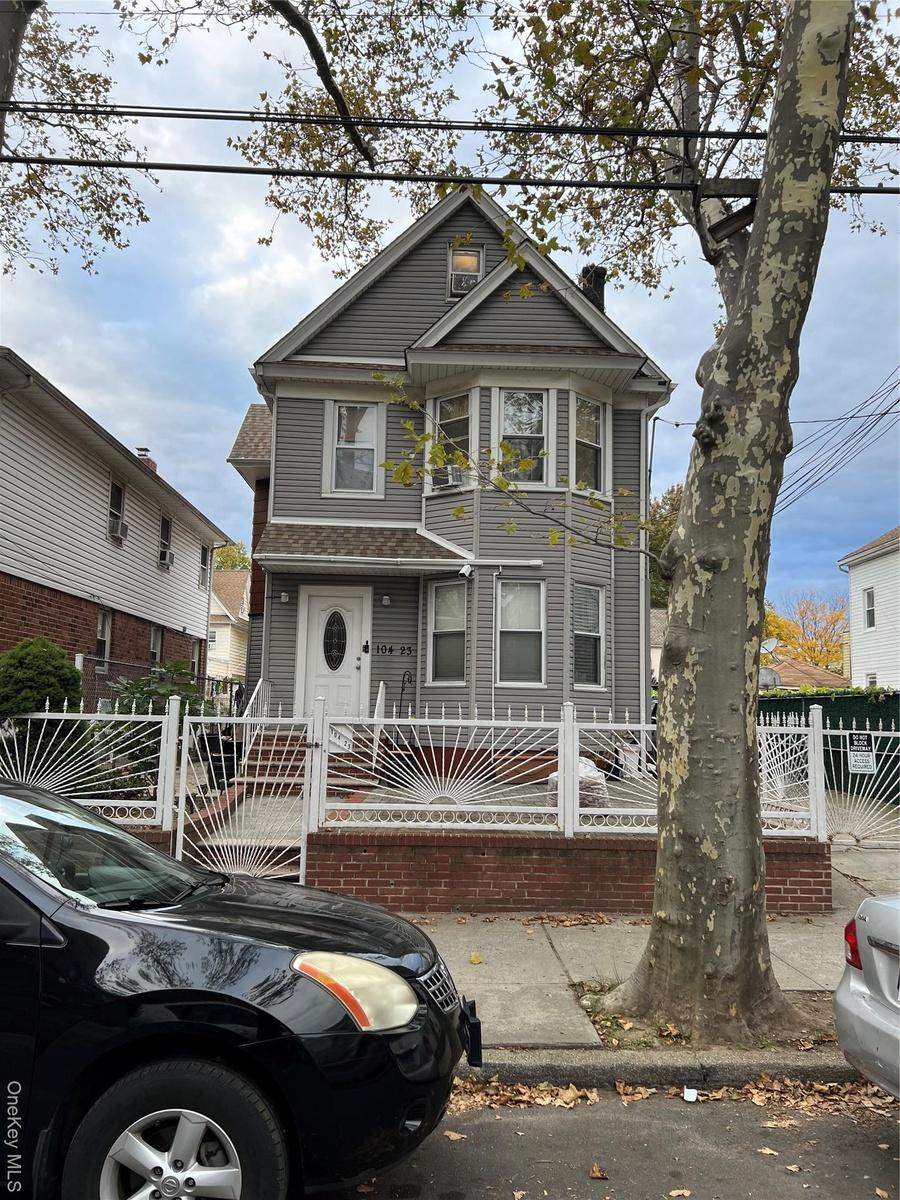 Victorian house with a fenced front yard, a chimney, and a gate
