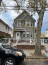 Victorian house with a fenced front yard, a chimney, and a gate