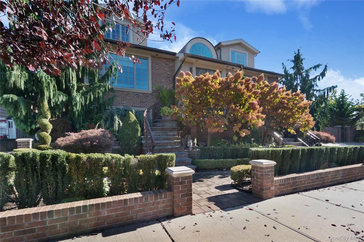 View of front of house with brick siding, stairs, and a patio area