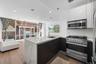 Kitchen featuring stainless steel appliances, modern cabinets, a peninsula, light stone countertops, and recessed lighting