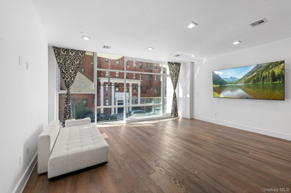 Unfurnished room with a wall of windows and dark wood finished floors
