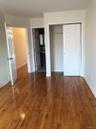 Unfurnished bedroom with dark wood-type flooring, a closet, and connected bathroom