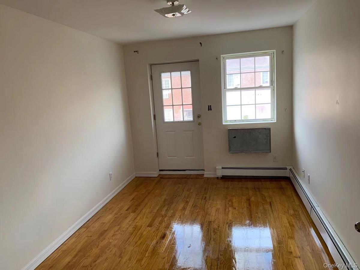 Entryway featuring a baseboard heating unit and wood finished floors