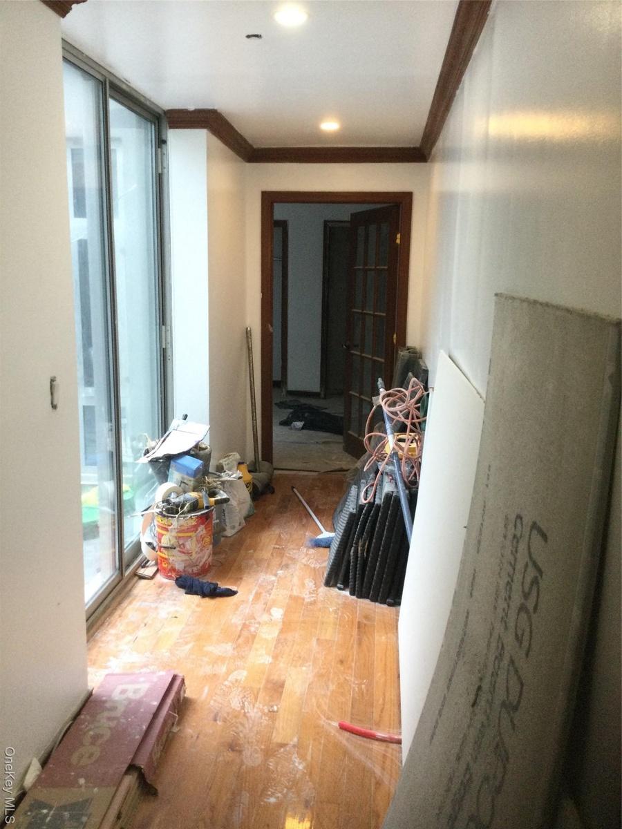 Hallway with ornamental molding, hardwood / wood-style flooring, and recessed lighting