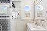 Bathroom featuring a sink, wainscoting, and tile walls
