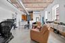 Living area featuring finished concrete floors, a high ceiling, and brick ceiling