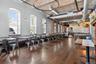 Dining room featuring brick wall, dark wood-style flooring, a towering ceiling, arched walkways, and brick ceiling