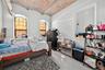 Bedroom featuring concrete flooring and brick ceiling
