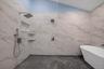Bathroom featuring a freestanding bath, lofted ceiling, and a marble finish shower