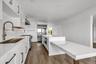 Kitchen featuring white cabinetry, recessed lighting, dark wood-type flooring, light stone countertops, and a kitchen island
