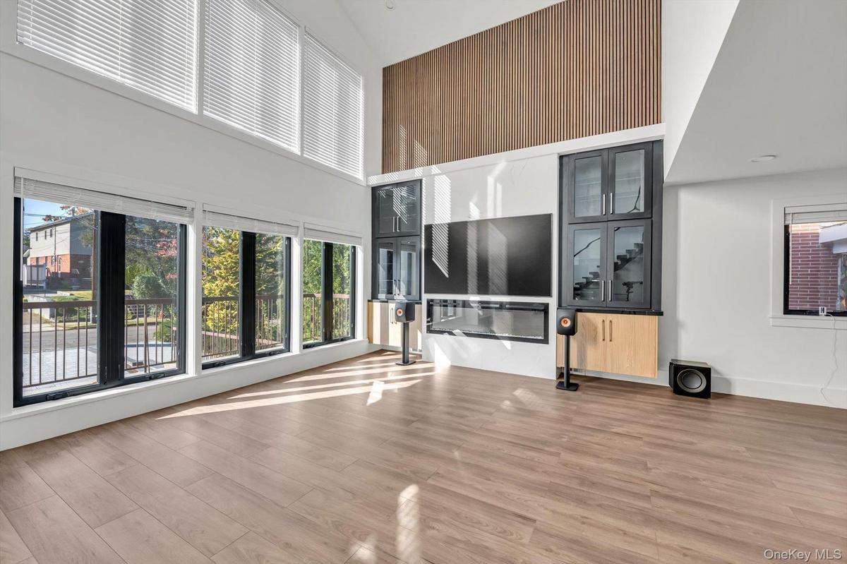 Unfurnished living room featuring a high ceiling and light wood-style floors