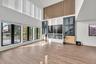 Unfurnished living room featuring a high ceiling and light wood-style floors
