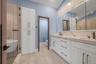 Full bath with double vanity, a marble finish shower, lofted ceiling, a soaking tub, and recessed lighting