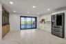Kitchen featuring stainless steel fridge, light marble finish flooring, recessed lighting, white cabinetry, and light stone counters
