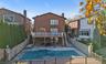 Back of property with stairs, a patio, brick siding, and a chimney