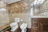 Full bathroom featuring tile walls, vanity, a bidet, a shower stall, and dark wood-type flooring
