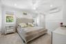 Carpeted bedroom with ornamental molding, a ceiling fan, recessed lighting, and a wall mounted air conditioner