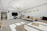 Carpeted living room with a raised ceiling, recessed lighting, arched walkways, ornamental molding, and a chandelier