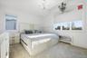 Bedroom with radiator, light carpet, and a chandelier