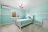 Carpeted bedroom featuring a wall unit AC, radiator heating unit, and a chandelier