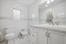 Half bath with tile walls, vanity, a bidet, recessed lighting, and light marble finish flooring